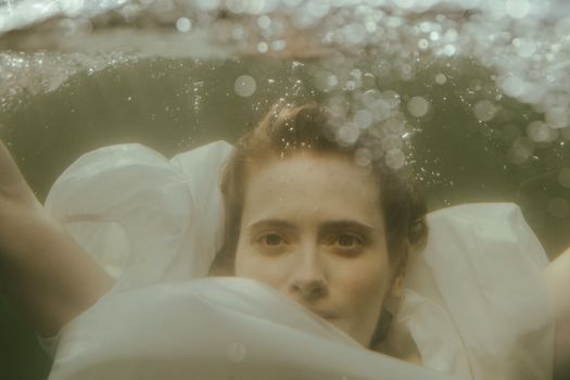 一幅描绘了有空灵气泡的女人的水下肖像，宁静而祥和