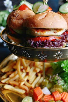 Delicious gourmet burgers with fresh veggies and fries presented on a stylish platter, perfect for food enthusiasts.