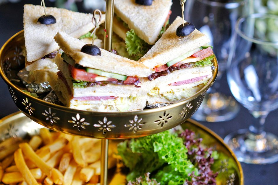 A triple-decker turkey club sandwich cut diagonally into two triangles, showing layers of turkey, bacon, lettuce, and tomato between three slices of toasted bread, secured with toothpicks.