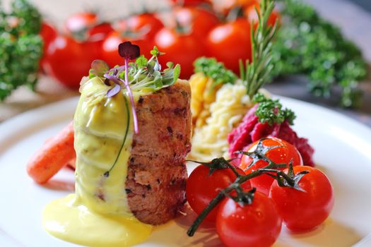 Close-up of a gourmet dish featuring fresh tomatoes and a creamy sauce on a white plate.