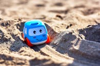 Blue and White Toy Car on Brown Sand