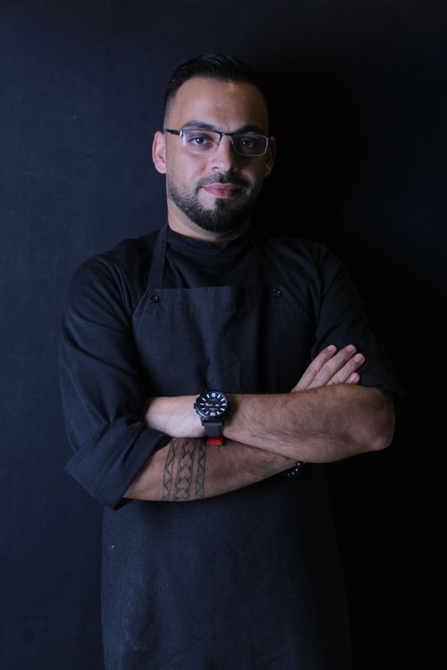 Free A confident man with glasses and beard posing with crossed arms in a studio portrait. Stock Photo
