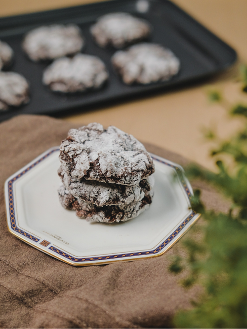 A stack of thick cowboy cookies studded with chocolate chips, toasted pecans, and shredded coconut, with one cookie broken in half to show the chewy interior.