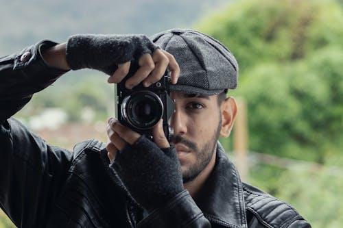 Free Man in Black Leather Jacket and Beret Holding a Camera Stock Photo