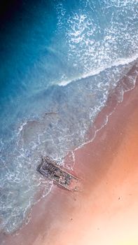 Top view of clear blue water of sea with foamy waves rolling on sandy shore in tropical resort in nature