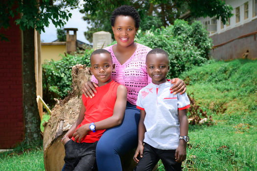 A joyful mother with her two sons posing outdoors in a garden setting.
