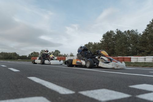 Free Dynamic go-kart racing on an outdoor track featuring adult drivers in action. Stock Photo