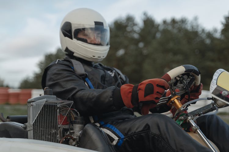 Go Kart Racer Wearing Protective Gears While Holding The Steering Wheel 