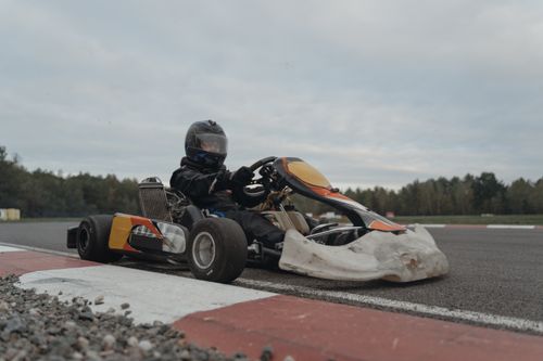 Free A go-kart driver in full gear navigating a racetrack during a competition. Stock Photo