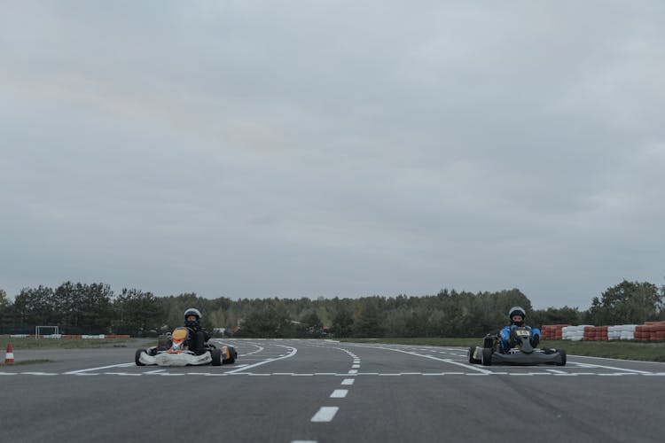 People Driving Go-Karts In Racetrack