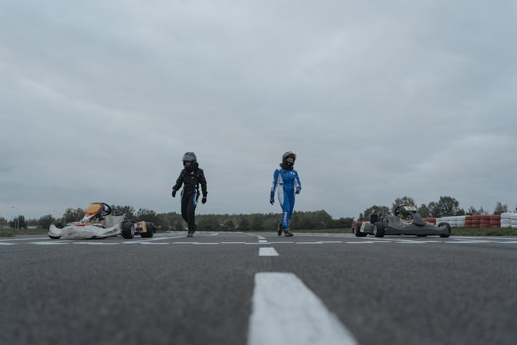 2 Persons Walking On Racing Track