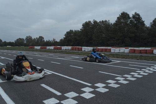 Free Two racers compete at the starting line on a go-kart race track. Stock Photo