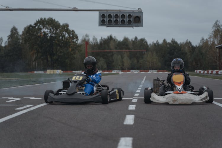 Athletes Driving Go-Karts In Racetrack