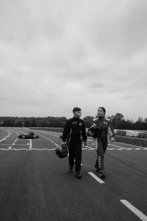 Free Two racers in gear walking on a kart racing track in grayscale. Stock Photo