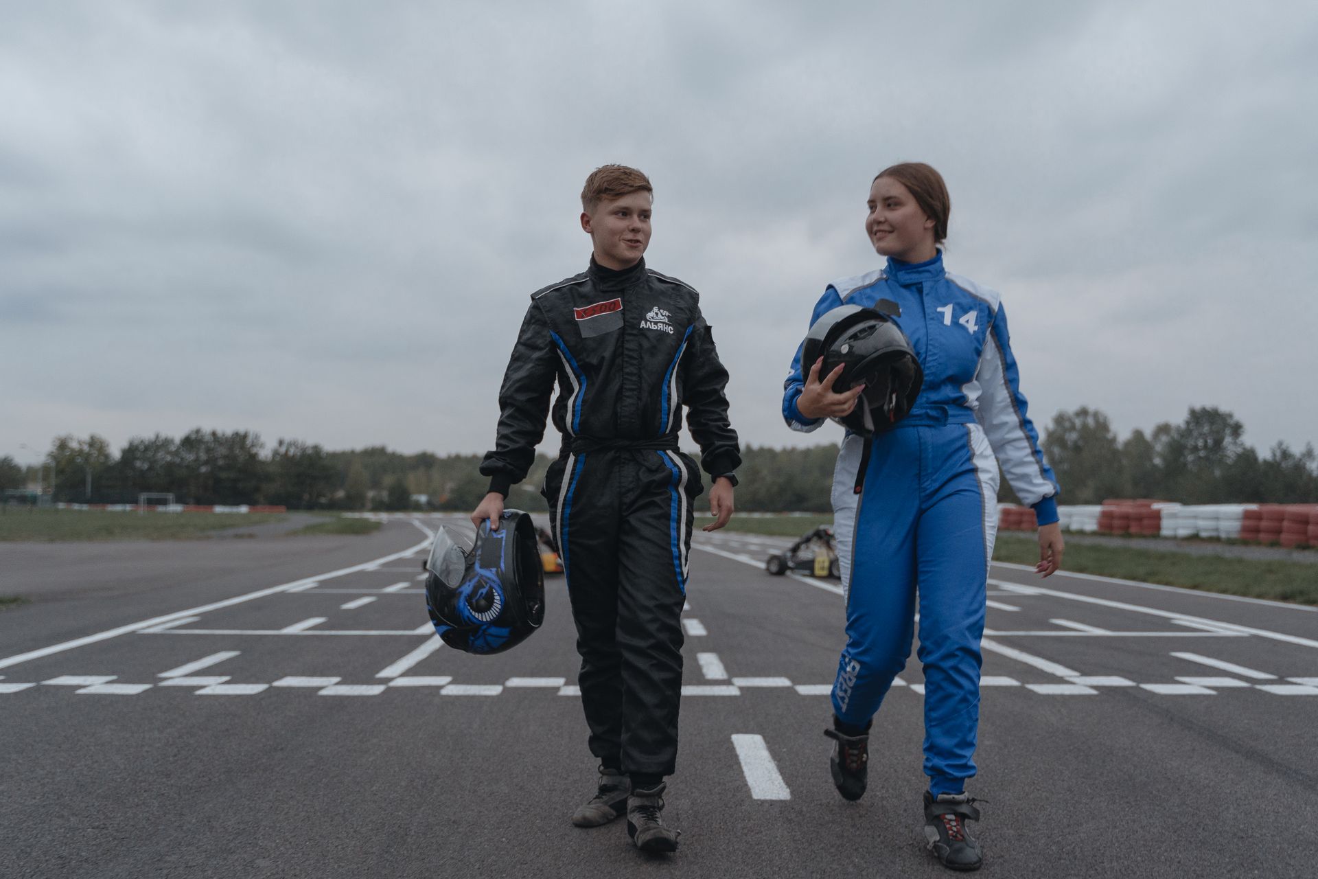 Two Go-Kart Drivers Walking in Racetrack