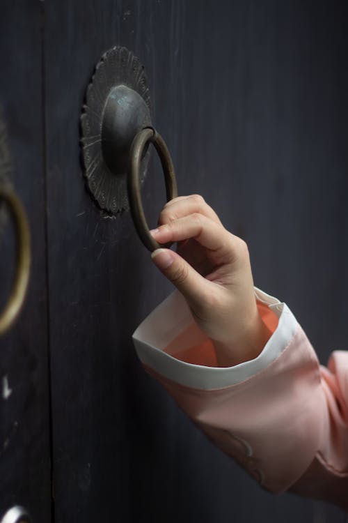 Close-Up Shot of a Person Holding a Door Knocker