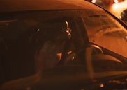 A woman driving at night in Kilamba, showcasing a serene and focused expression.