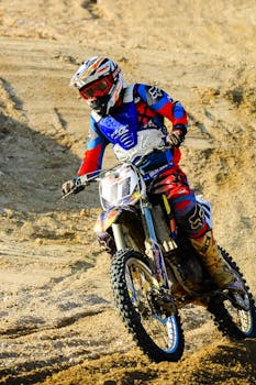 越野摩托车手在沙质地形中充满活力地穿行，展示着速度与技巧