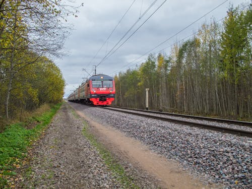 Red Train on a Railway Under Cloudy Sky