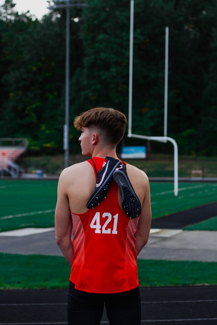 Sportive Man With Football Boots On Field