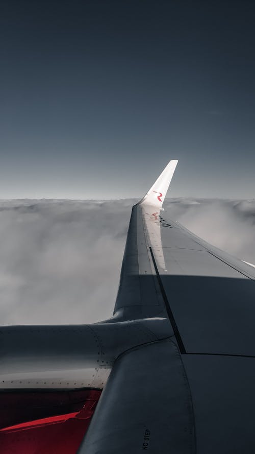 White Airplane Wing over White Clouds