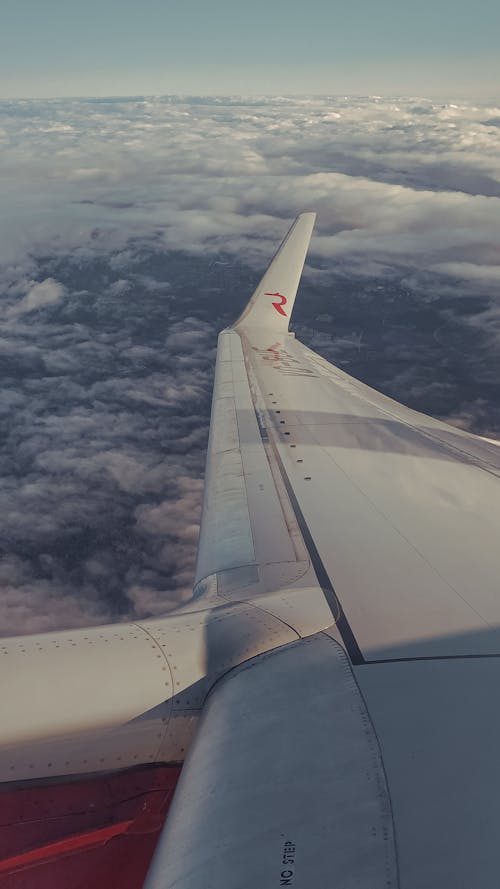 Airplane Wing over White Clouds