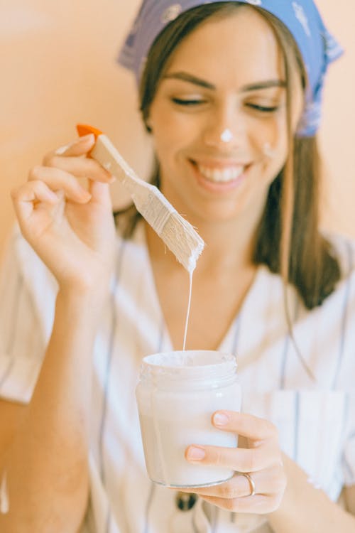 Woman Holding Paintbrush and a Jar