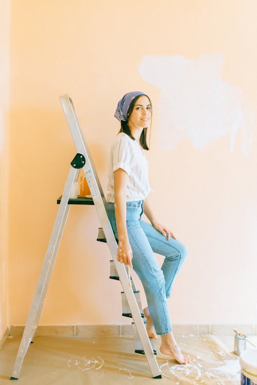 Free Woman Sitting on a Ladder Stock Photo