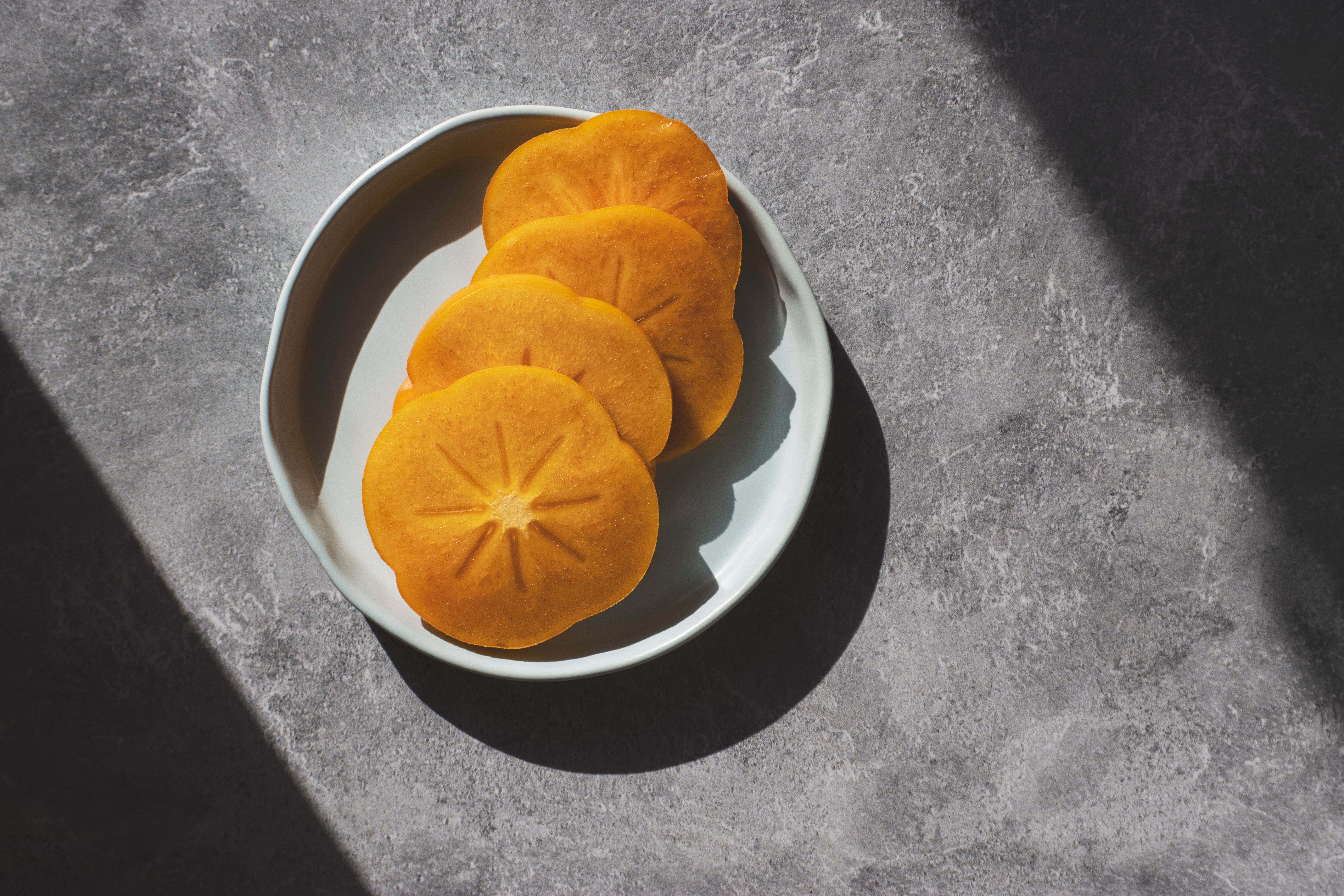 Thinly sliced Fuyu persimmons tossed with peppery greens, toasted nuts, and a light vinaigrette for a bright fall salad.