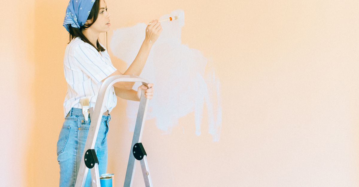 Decorator painting interior trim with a brush — interior work fills the autumn and winter months when exterior demand drops
