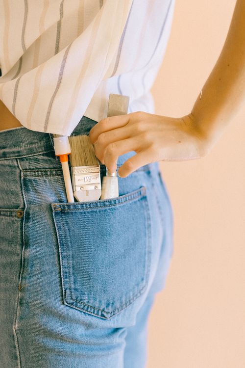 Person Holding a Paint Scraper in Her Pocket · Free Stock Photo