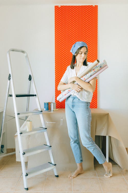 Woman Carrying Rolls of Wallpaper