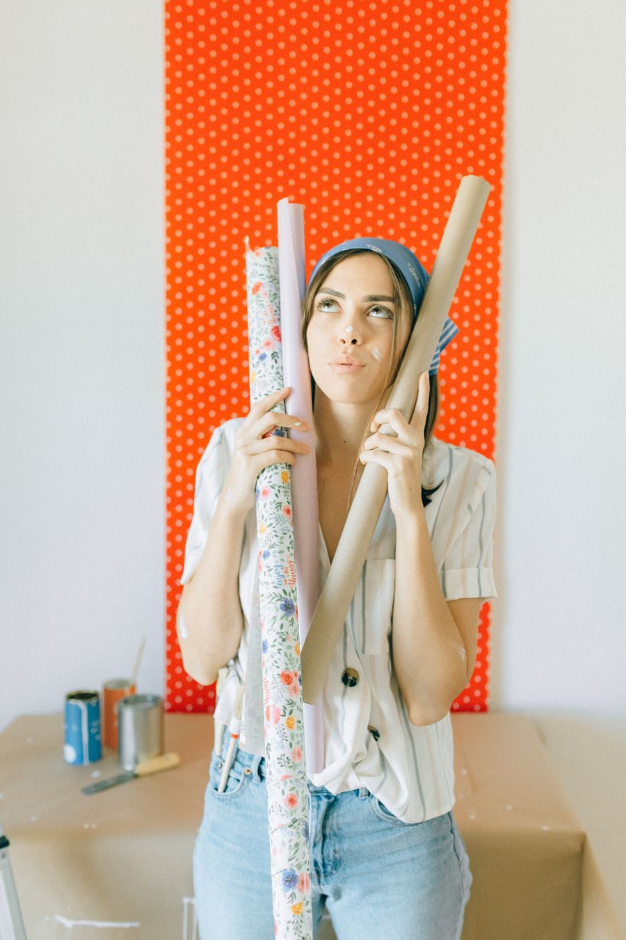 Woman planning a renovation with wallpaper rolls