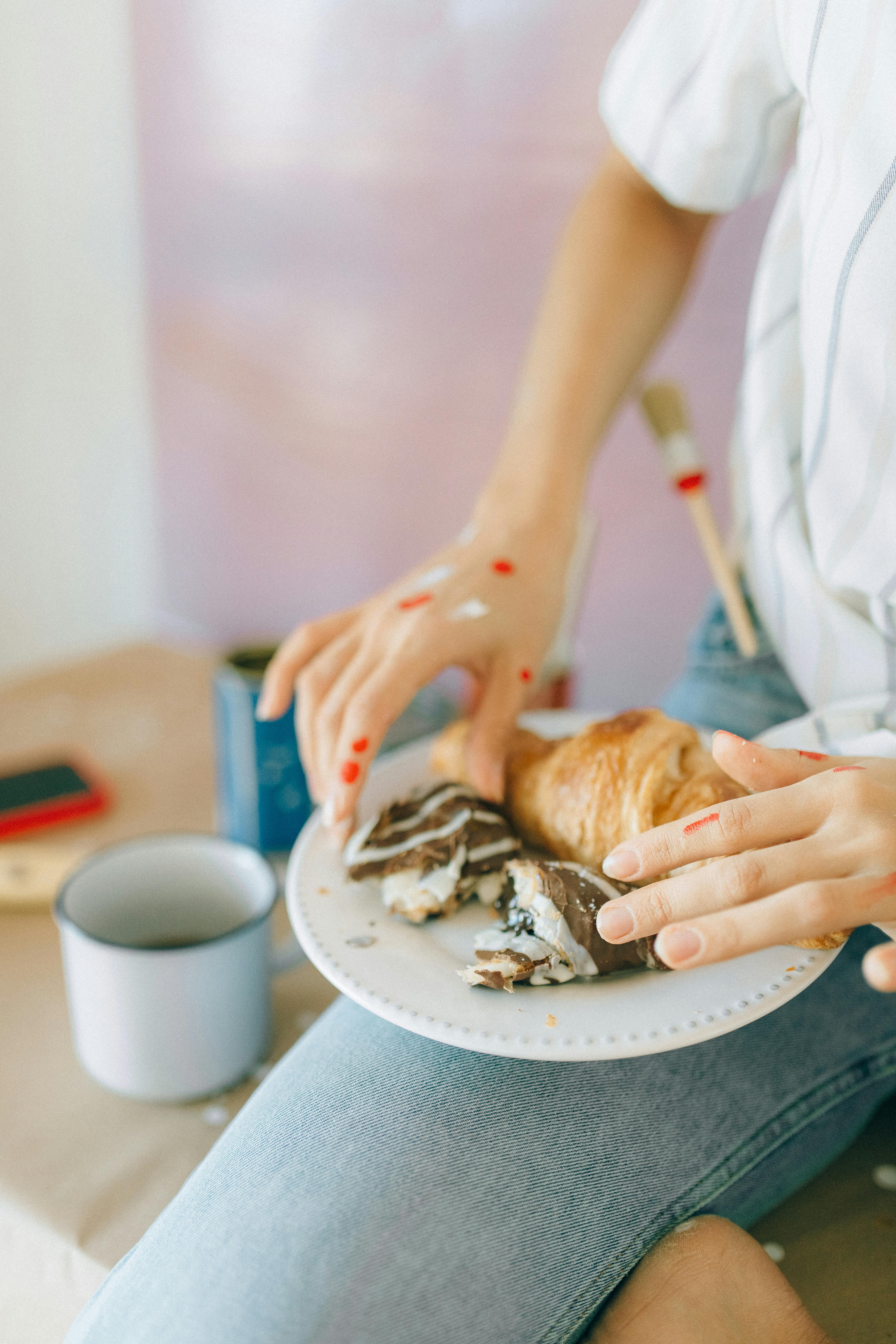 person holding bread with white cream