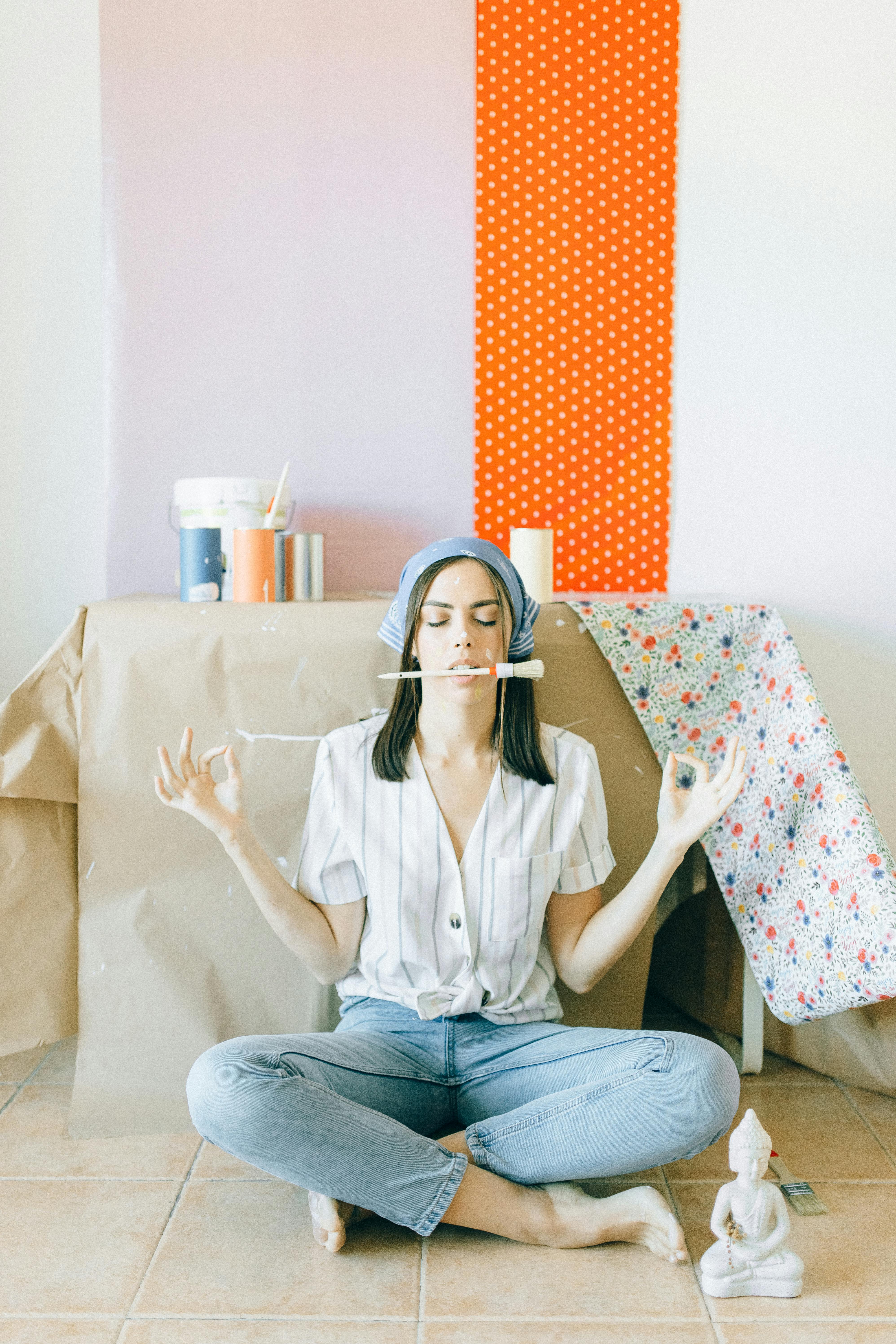 woman in white button up shirt and blue denim jeans sitting on bed