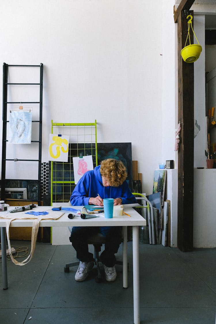 Faceless Male Painter Working In Studio At Table