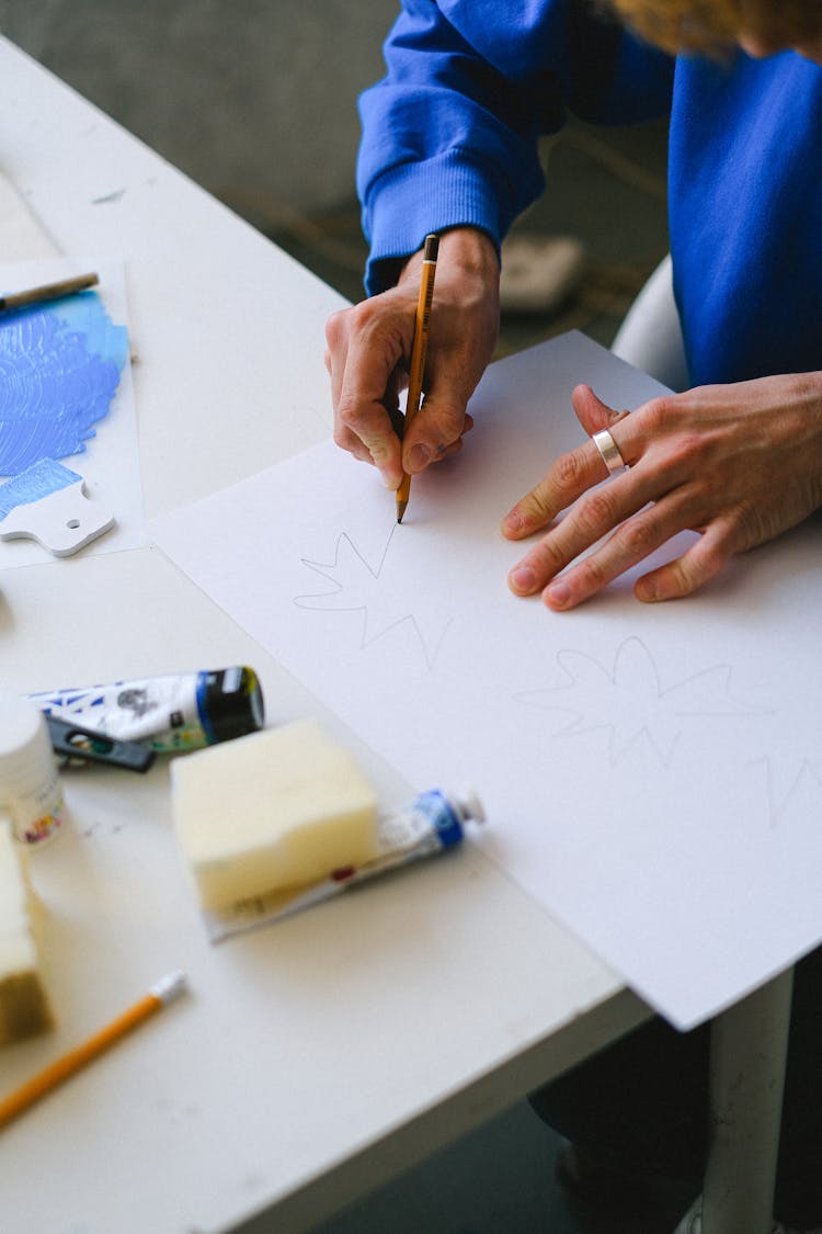 Anonymous Guy Drawing On Paper With Pencil