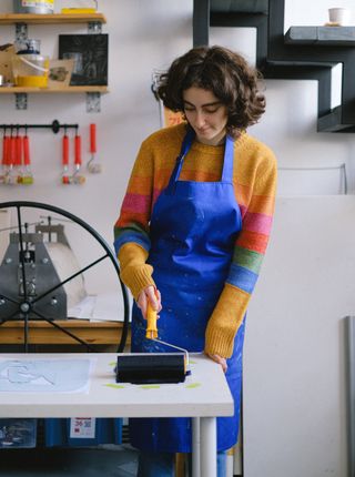 Printmaker in an apron at the studio bench — Anna Shvets on Pexels