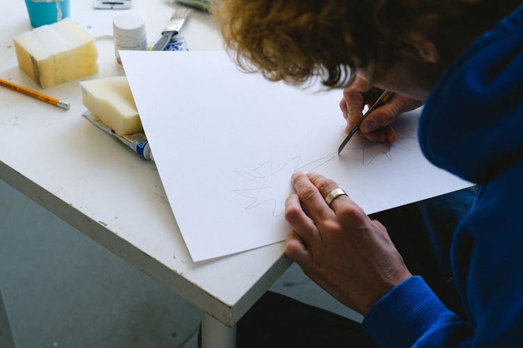 Anonymous Guy Cutting Paper With Knife