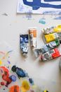 Workplace of artist with paper drafts and paint tubes