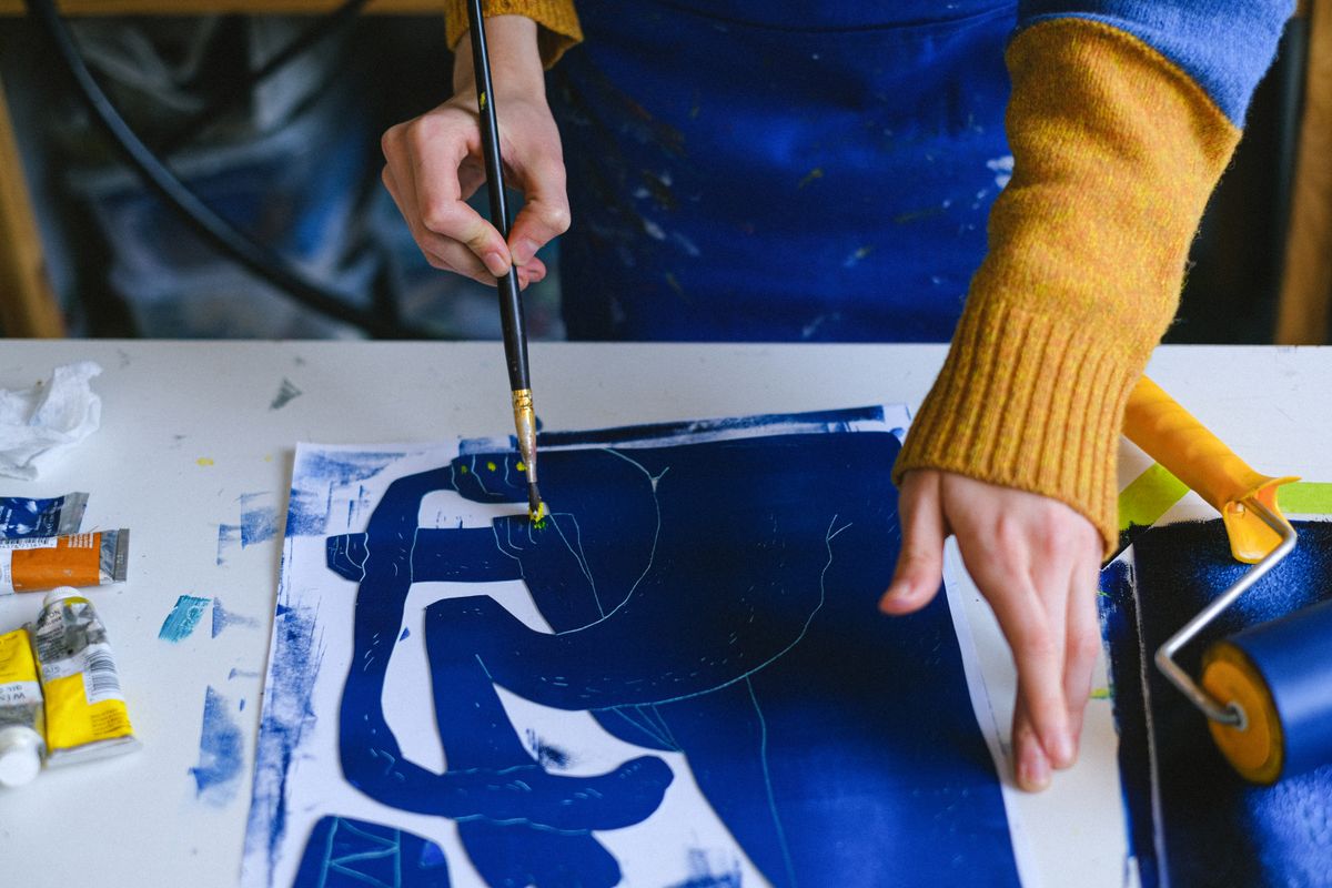 Artista al lavoro con pennello e tavolozza di colori in uno studio creativo