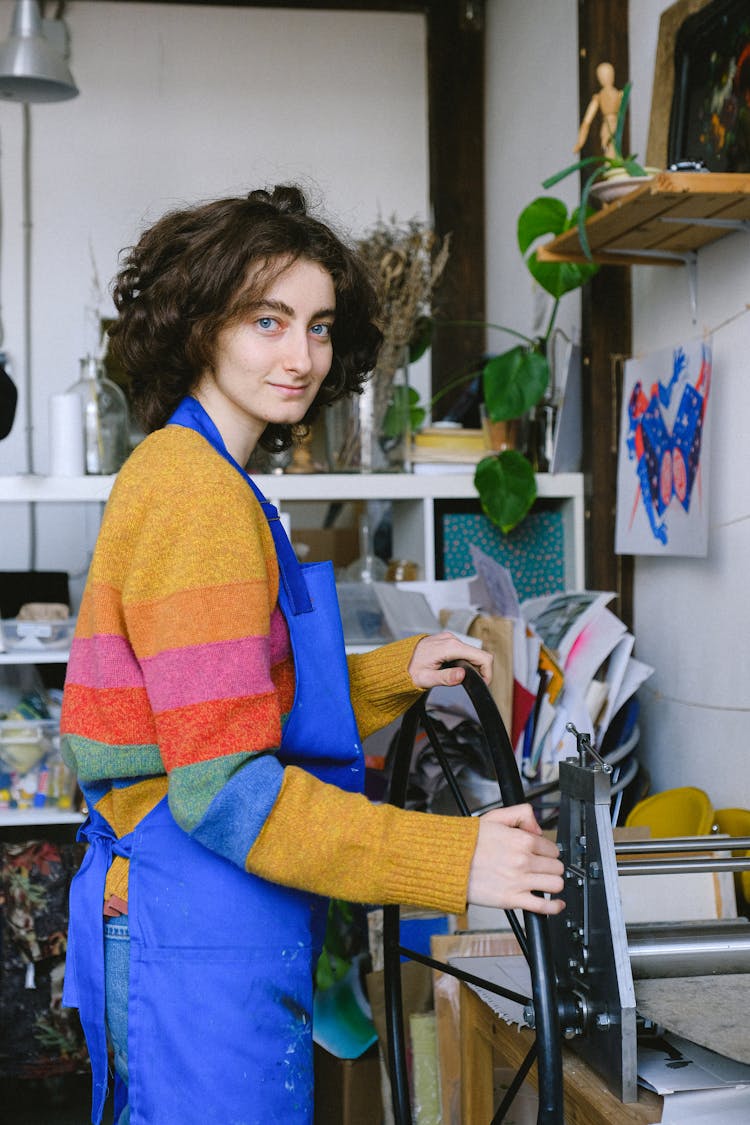 Young Craftswoman Printing Etching Picture On Press Machine