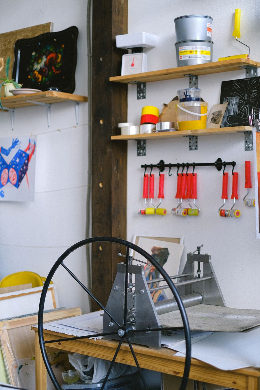 A print studio wall with brayers, ink tins and an etching press, by Anna Shvets on Pexels
