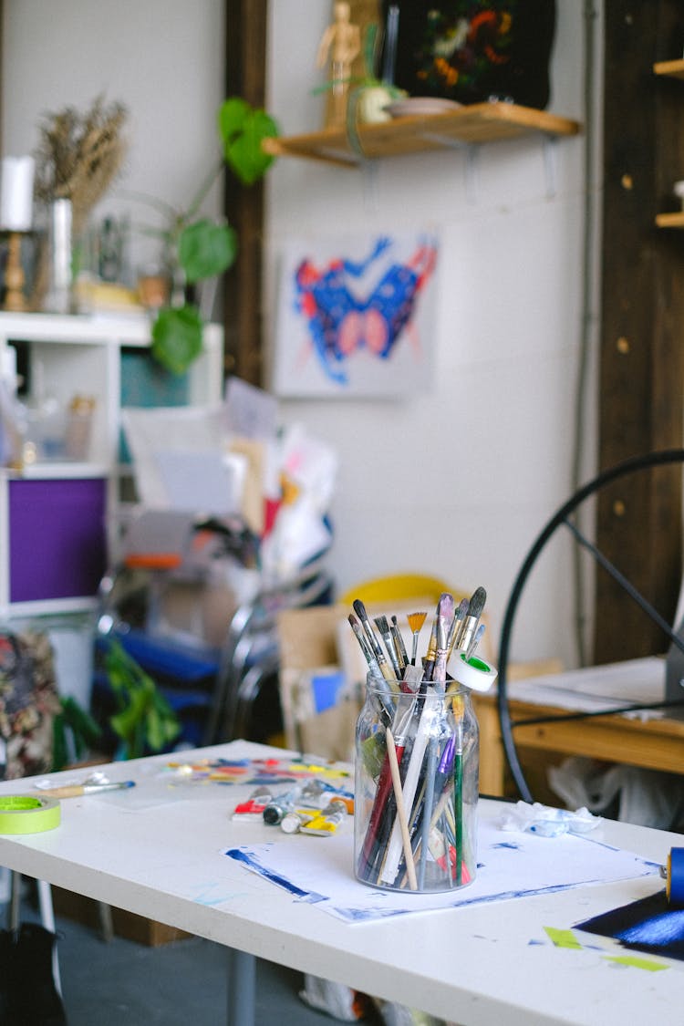 Paint Brushes In Jar On Table In Professional Craft Shop