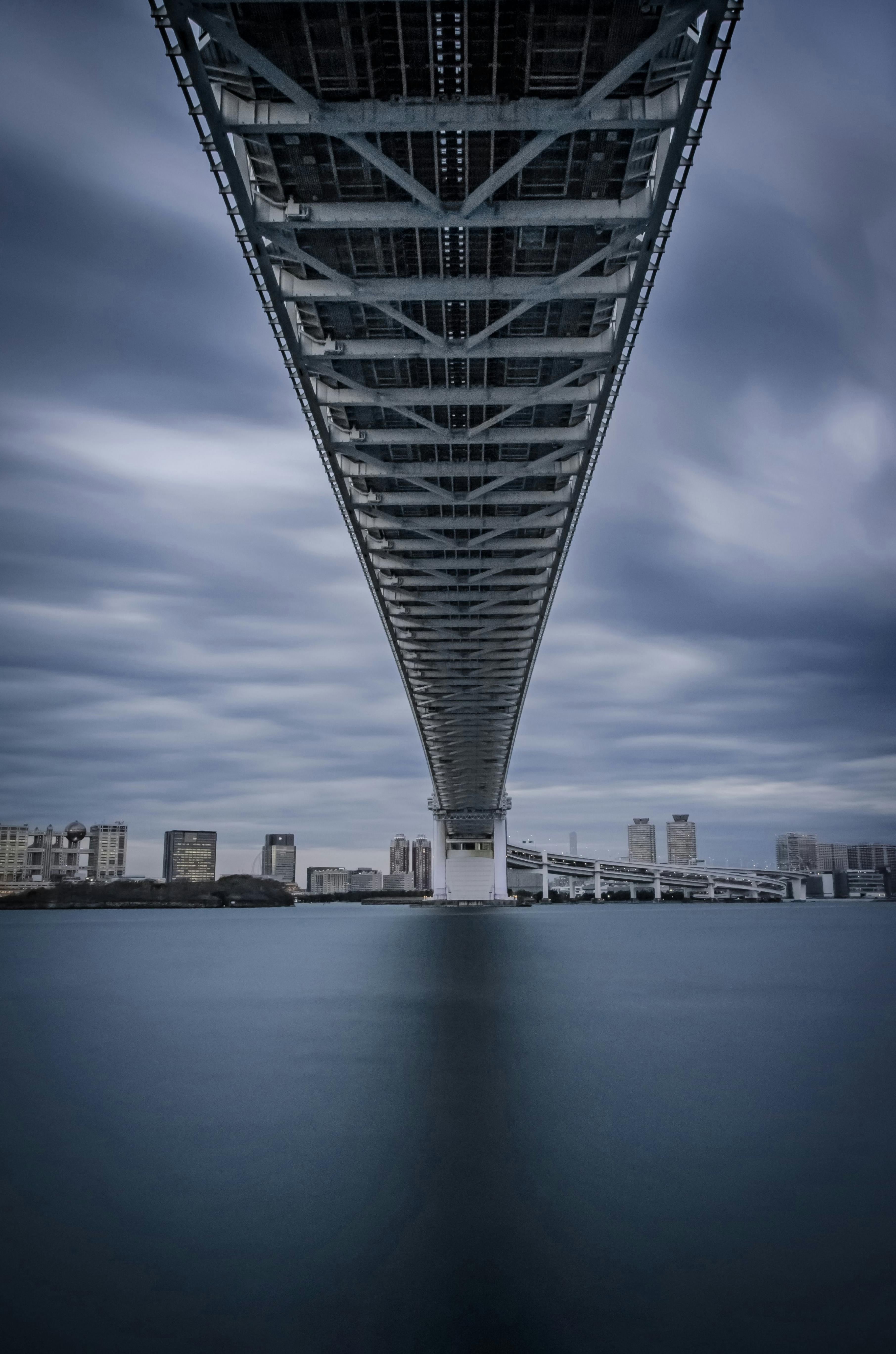 modern bridge over calm river in city