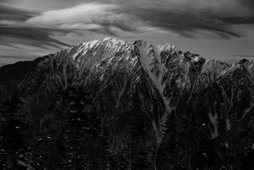 Stunning black and white view of a snow-capped mountain, showcasing rugged beauty and serene wilderness.