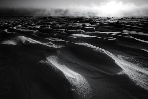 Black and white of summer desert terrain with sandy hills in foggy weather