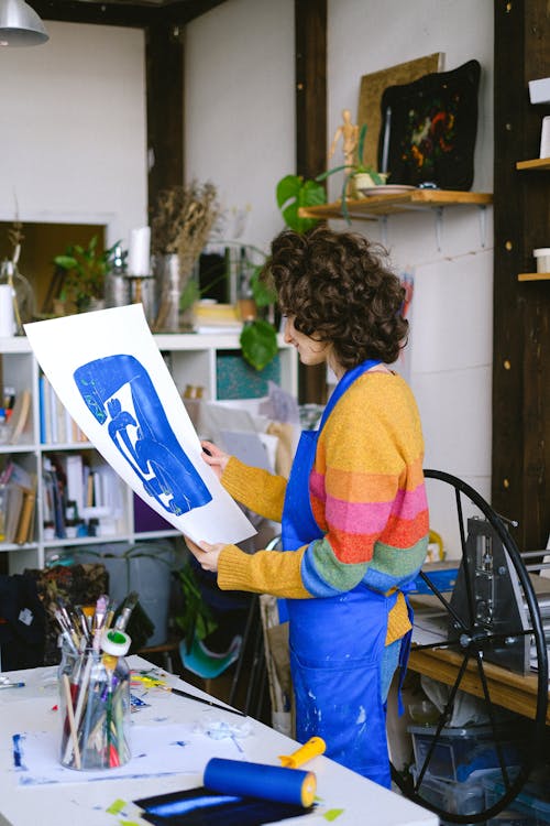 Free Curly woman with painting in studio Stock Photo