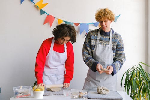 Focused colleagues molding clay in workshop