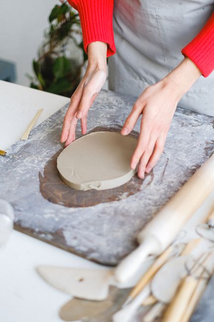 Fotomural Manos creando cerámica en un estudio, capturando el arte de la moldura de arcilla.